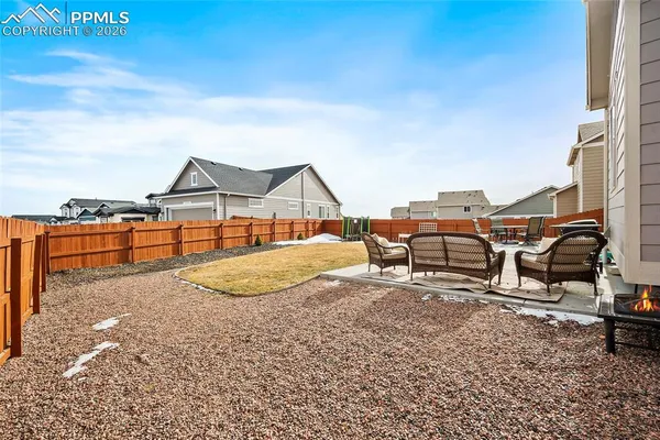 a backyard of a house with table and chairs