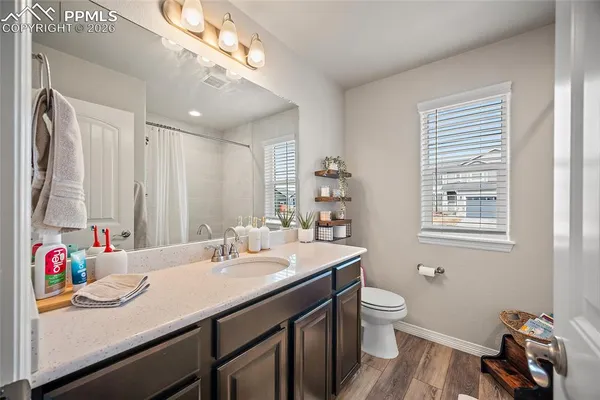 a bathroom with a sink a toilet and a large mirror