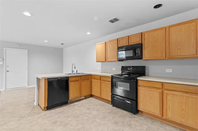 a view of an empty room with a sink and cabinets