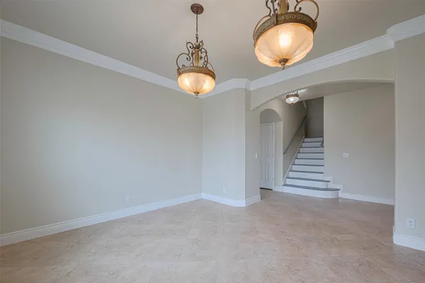 an empty room with chandelier and windows