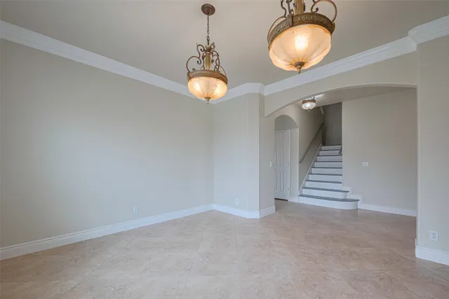 an empty room with chandelier and windows
