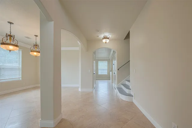 a view of a livingroom with a fireplace a ceiling fan and windows