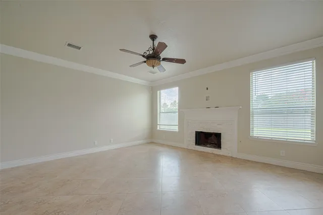a view of empty room with fireplace and window