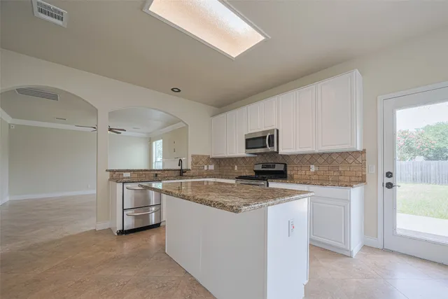 a kitchen with stove and cabinets