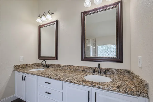 a bathroom with a granite countertop sink a toilet and a large mirror