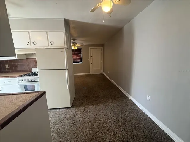 a view of a kitchen with a refrigerator a microwave and a sink
