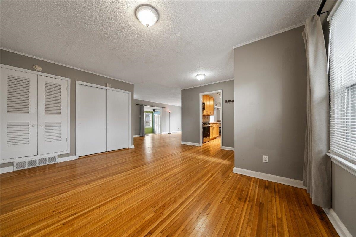 1073 Ivy Road Memphis, TN 38117 - Photo 2 of 33 a view of an empty room with wooden floor and a window