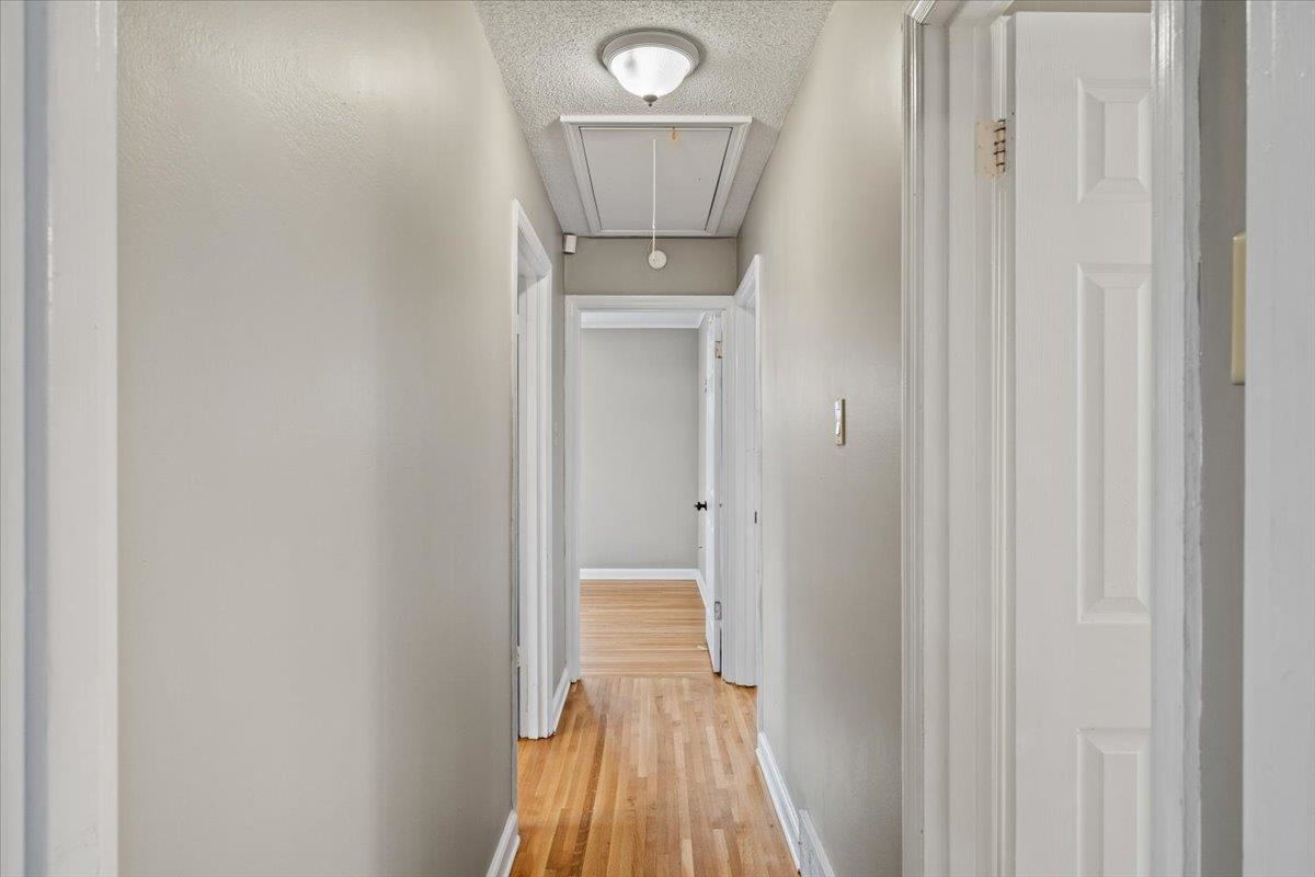 1073 Ivy Road Memphis, TN 38117 - Photo 21 of 33 a view of a hallway with wooden floor and a bathroom