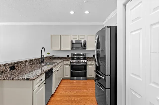a kitchen with stainless steel appliances granite countertop a refrigerator stove and oven
