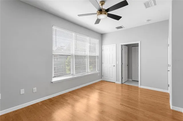 a view of an empty room with a window and wooden floor