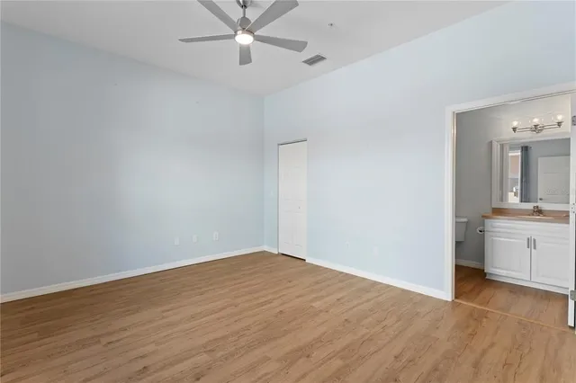 wooden floor in an empty room with a bathroom