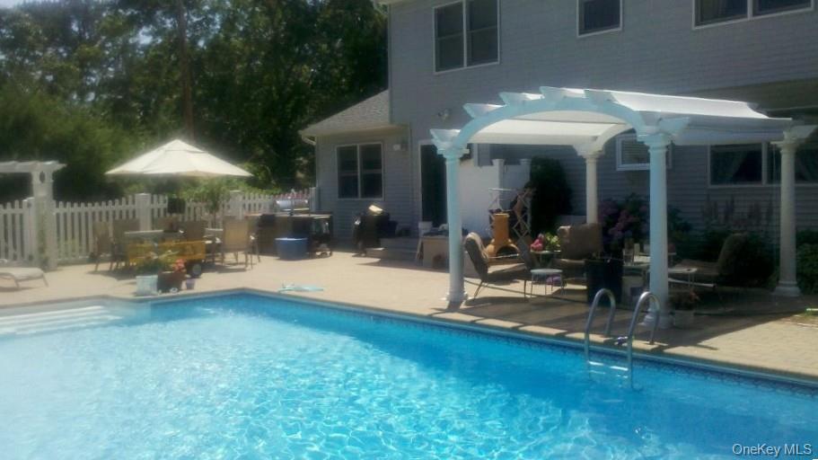 96 West Tiana Road Hampton Bays, NY 11946 - Photo 2 of 21 Swimming pool with a pergola and a patio area