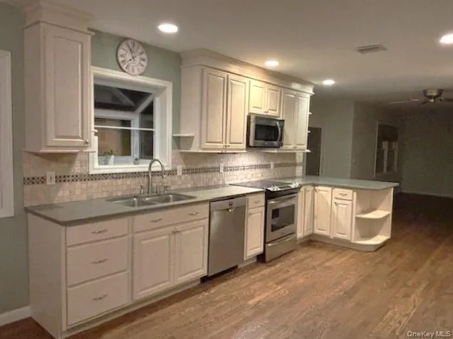 a kitchen with stainless steel appliances granite countertop a stove top oven a sink and a microwave