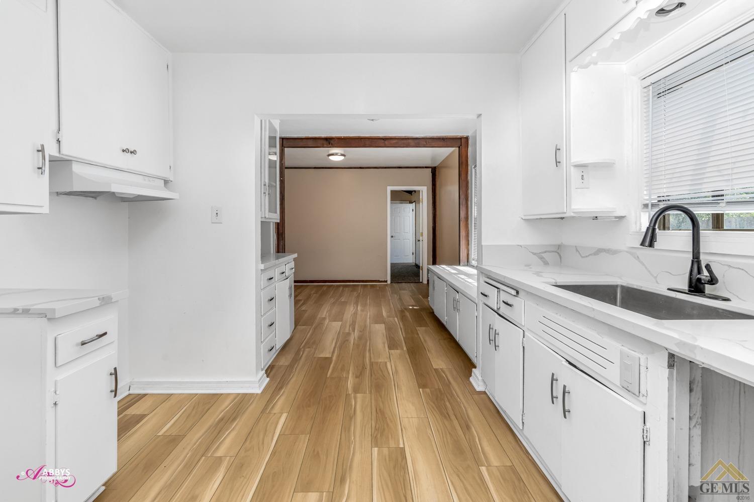 Undisclosed Address Bakersfield, CA 93308 - Photo 11 of 37 kitchen has quartz counters, farm style sink and new faucet with plenty of cabinets for storage.