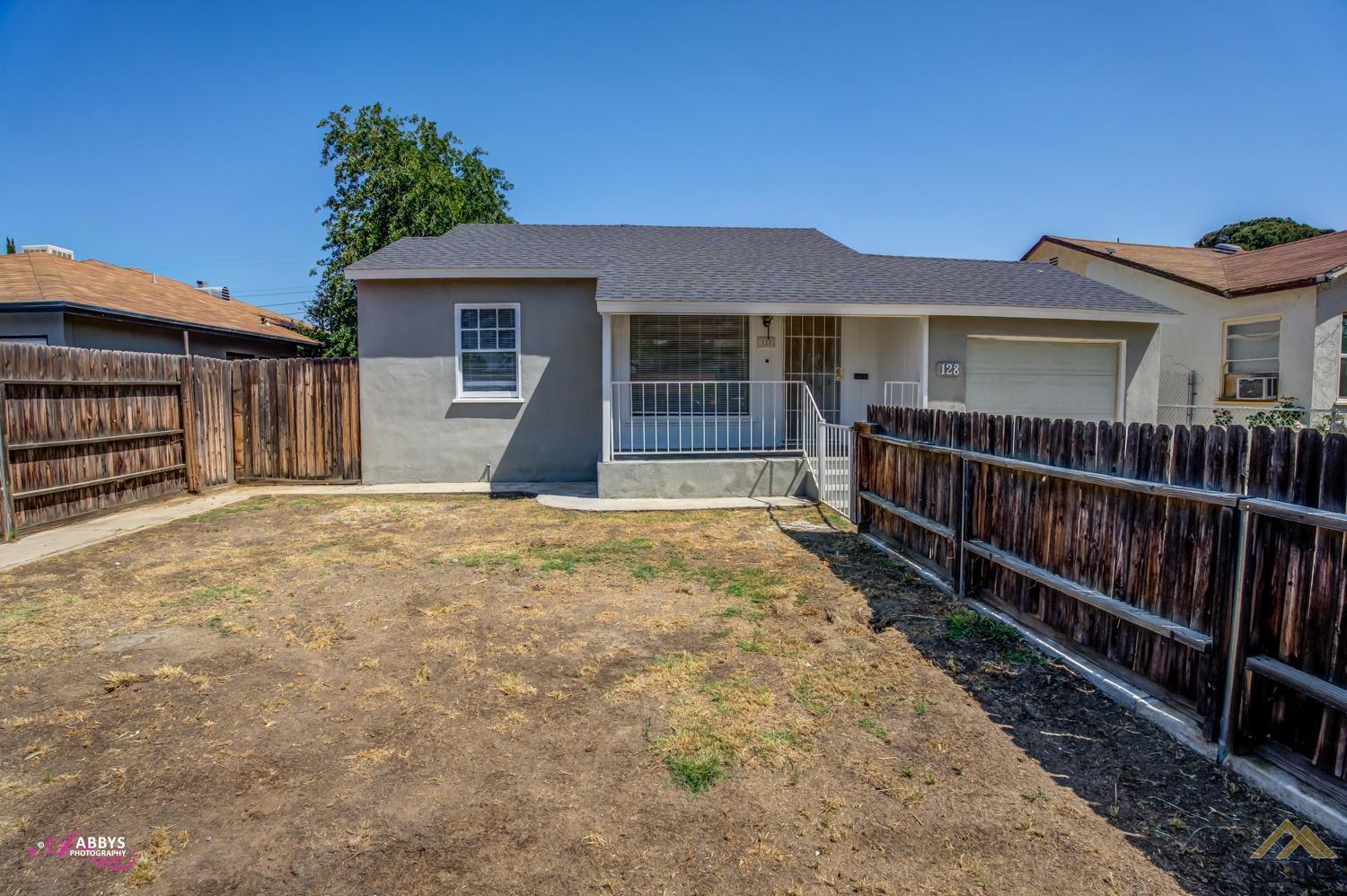 Undisclosed Address Bakersfield, CA 93308 - Photo 3 of 37 a front view of a house with glass windows and a yard