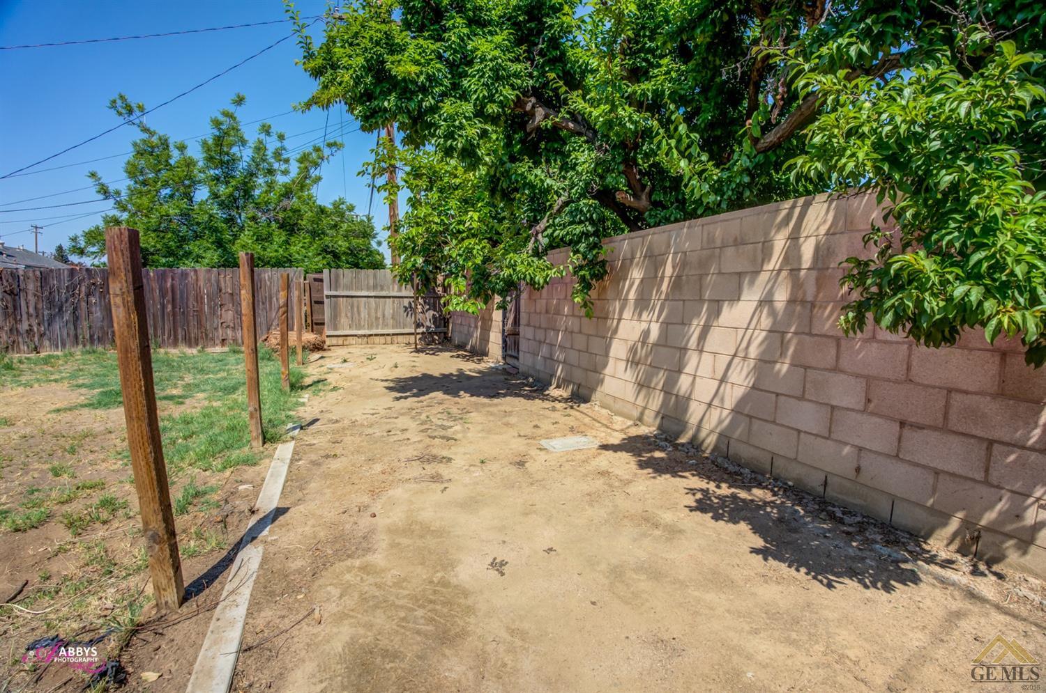 Undisclosed Address Bakersfield, CA 93308 - Photo 36 of 37 a view of a backyard with wooden fence and a large tree