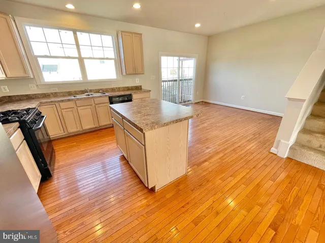 a kitchen with granite countertop wooden floors and wide window
