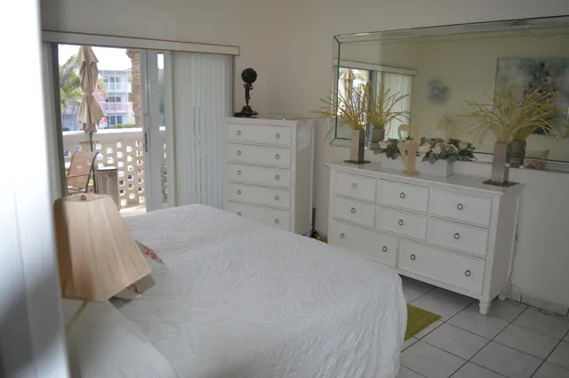 a bedroom with a bed and dresser with mirror