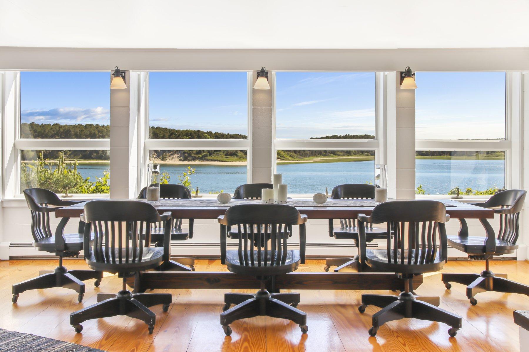 925 Chequessett Neck Road Wellfleet, MA 02667 - Photo 11 of 47 a view of a dining room with furniture large windows and wooden floor