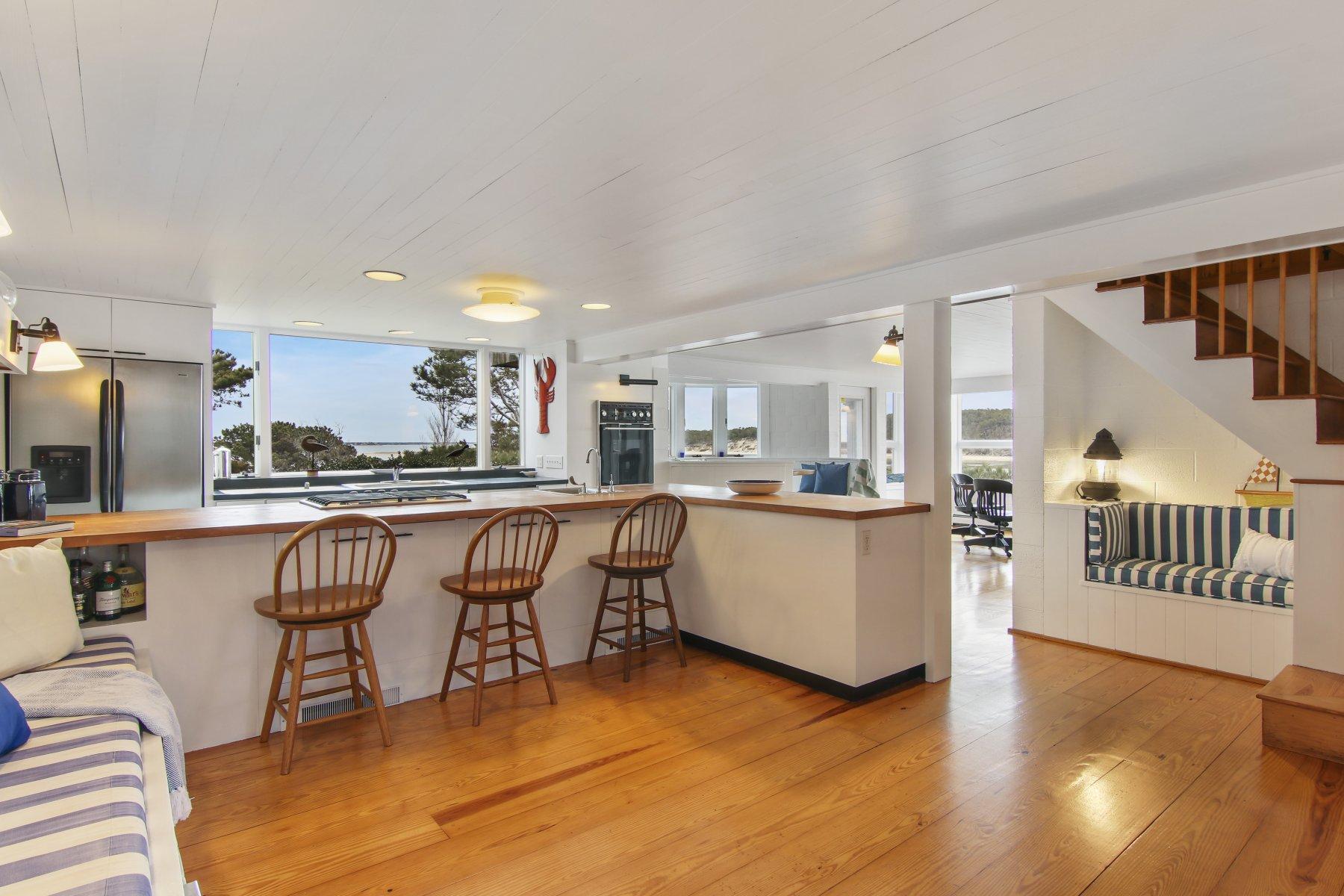 925 Chequessett Neck Road Wellfleet, MA 02667 - Photo 13 of 47 a kitchen with kitchen island granite countertop wooden floors and white cabinets