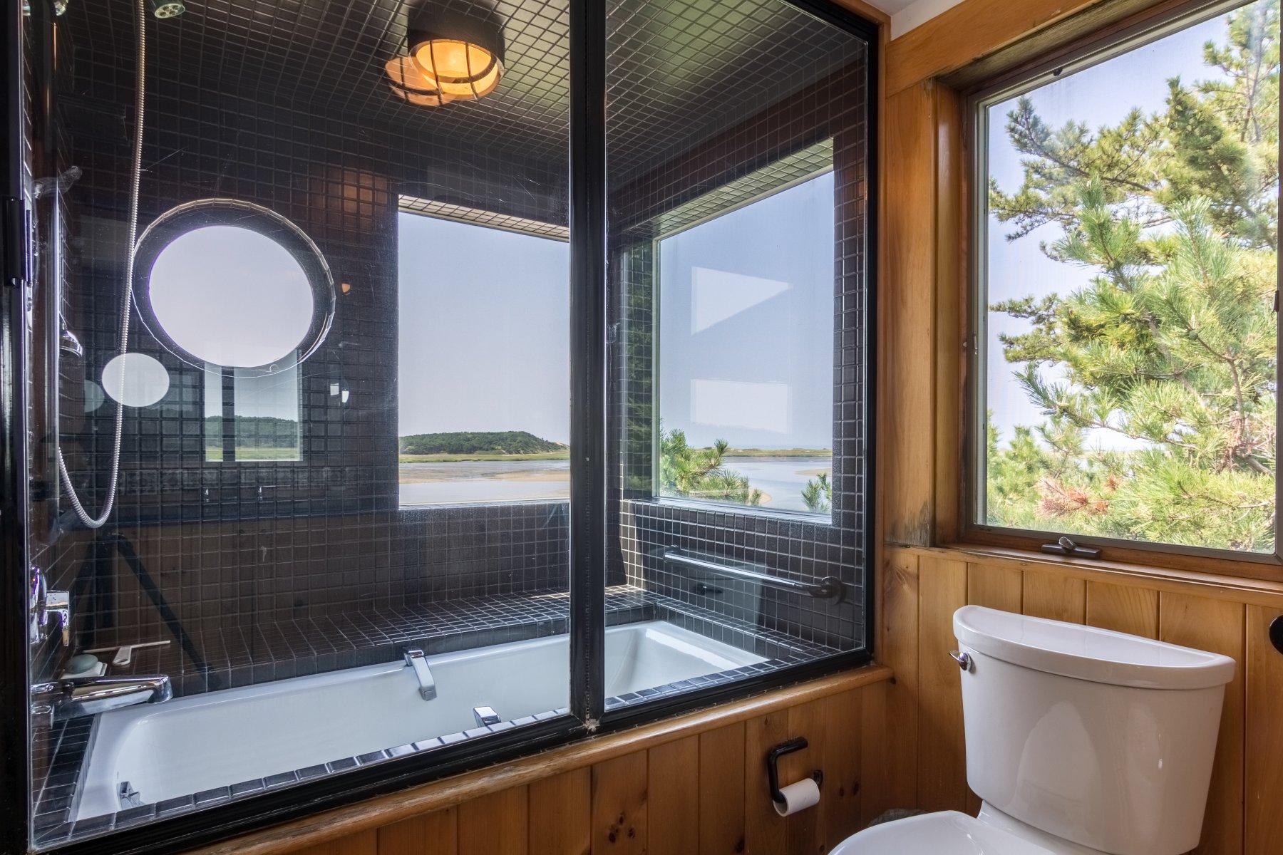925 Chequessett Neck Road Wellfleet, MA 02667 - Photo 25 of 47 a bathroom with a granite countertop sink mirror vanity and toilet
