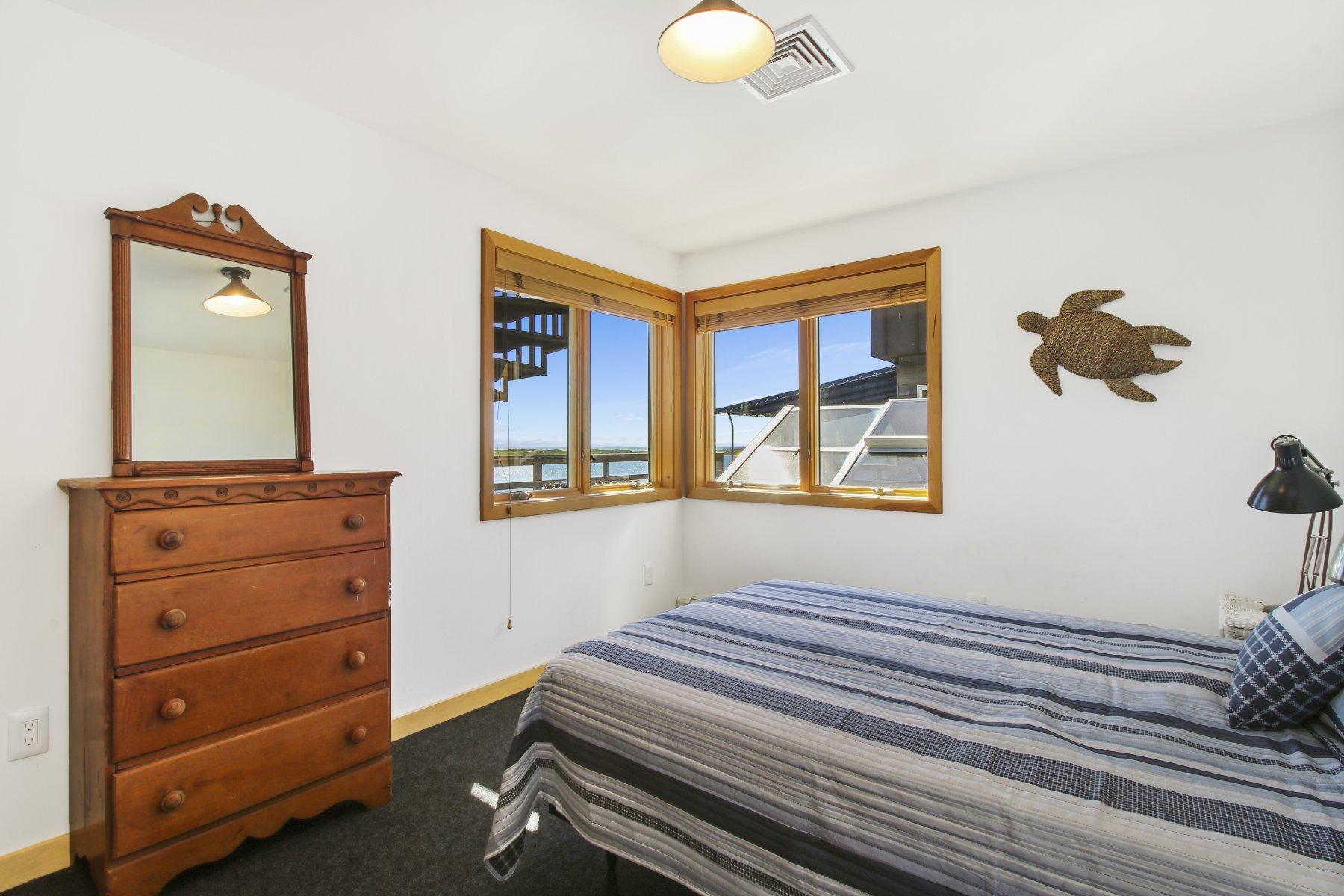 925 Chequessett Neck Road Wellfleet, MA 02667 - Photo 38 of 47 a bedroom with a bed and a mirror on the dresser