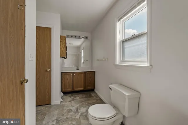 a bathroom with a toilet a sink and mirror