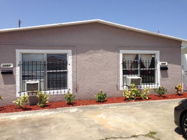 1050 West 7th Street, Unit 1050 Riviera Beach, FL 33404 - Photo 1 of 2 front view of a brick house with a small yard
