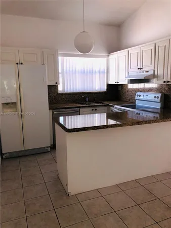 a kitchen with stainless steel appliances granite countertop a refrigerator a sink a stove a microwave and cabinets