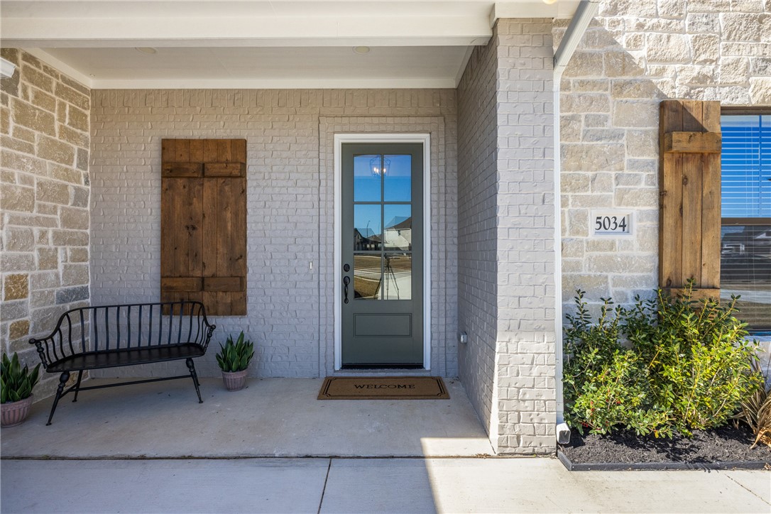 5034 Toscana Loop Bryan, TX 77802 - Photo 5 of 42 a front view of a house with a bench and potted plant