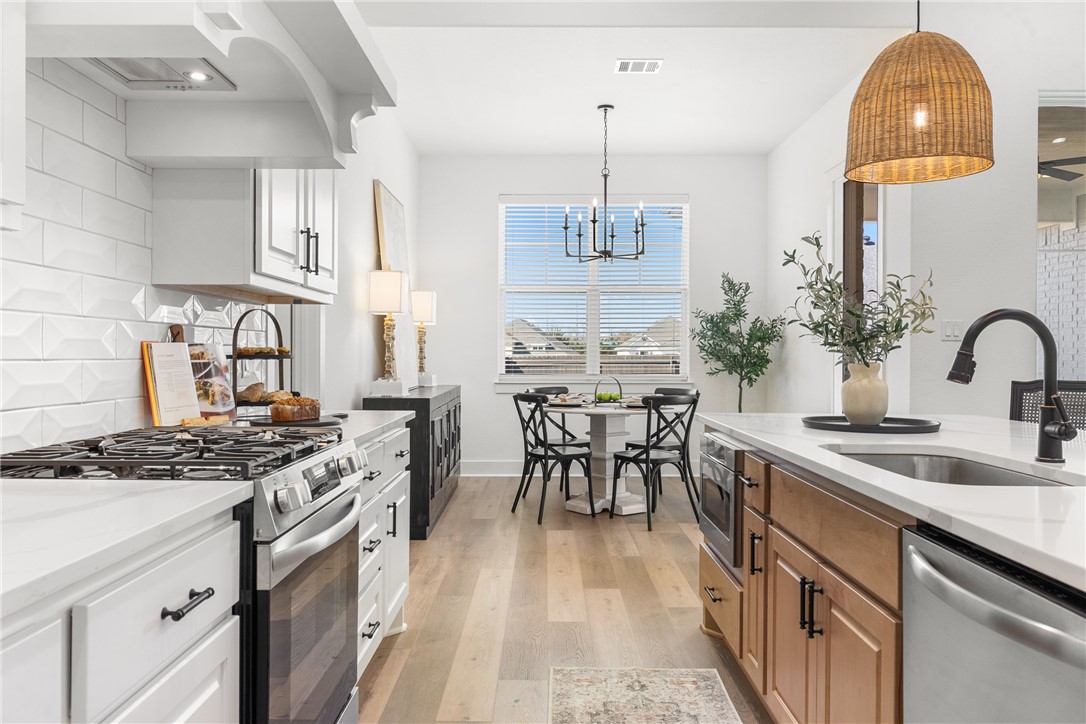 5034 Toscana Loop Bryan, TX 77802 - Photo 10 of 42 a kitchen with stainless steel appliances granite countertop a sink stove and cabinets