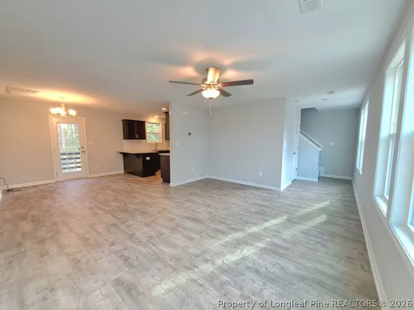a view of a livingroom with a ceiling fan a flat screen tv and a ceiling fan