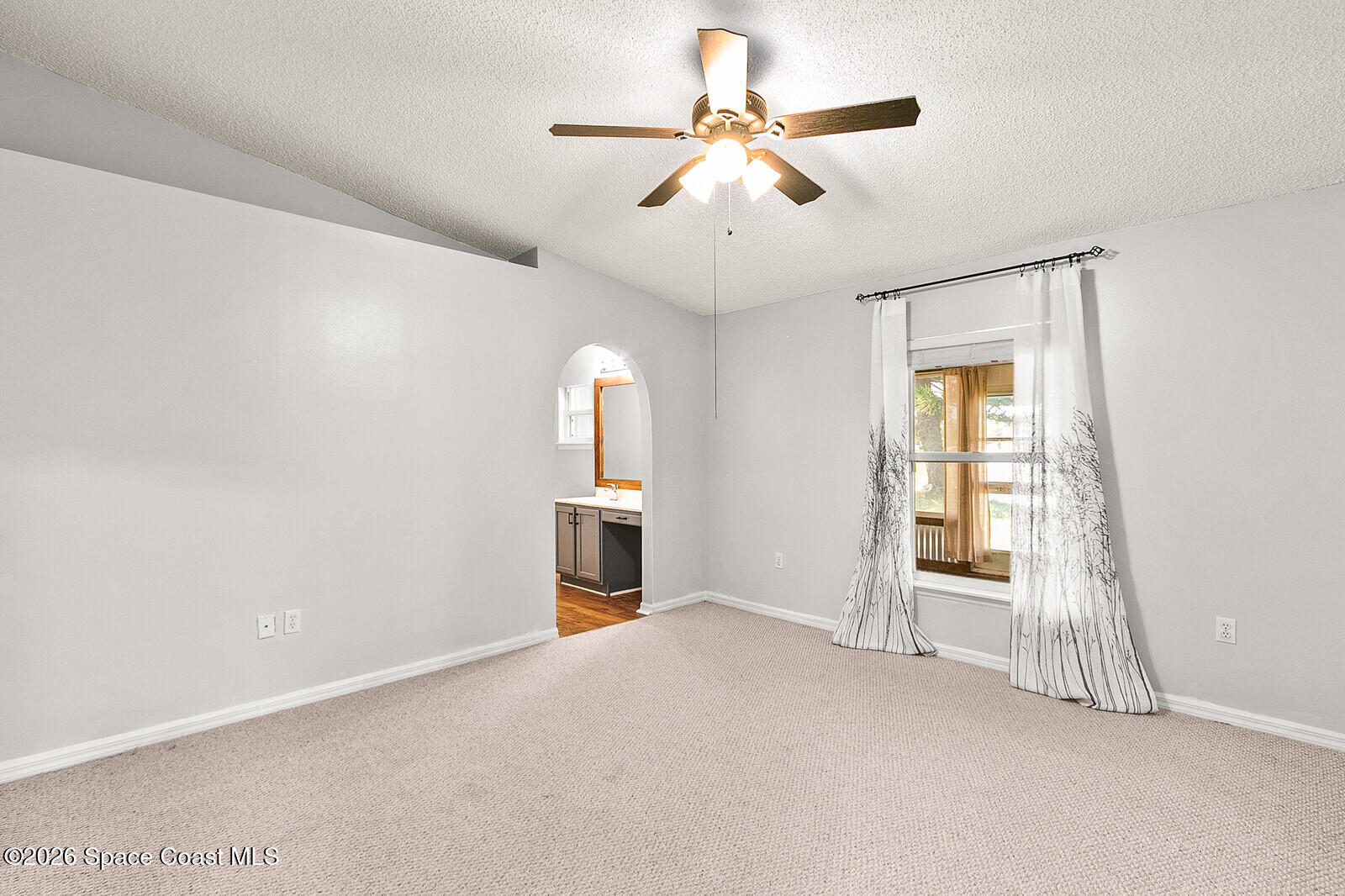 2152 Spring Creek Circle Palm Bay, FL 32905 - Photo 14 of 24 an empty room with chandelier fan and windows