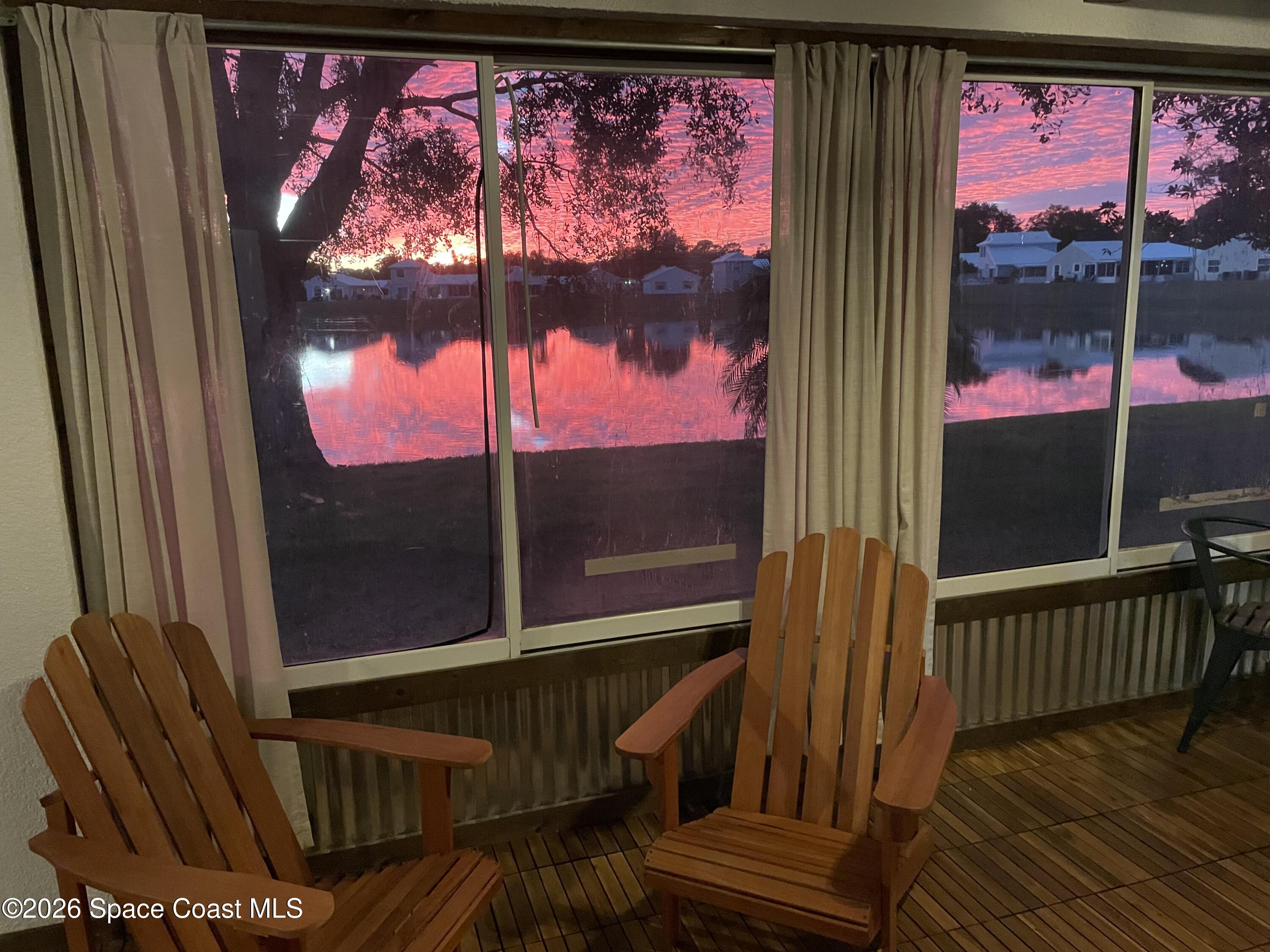 2152 Spring Creek Circle Palm Bay, FL 32905 - Photo 22 of 24 a view of a balcony with a red door and wooden floor