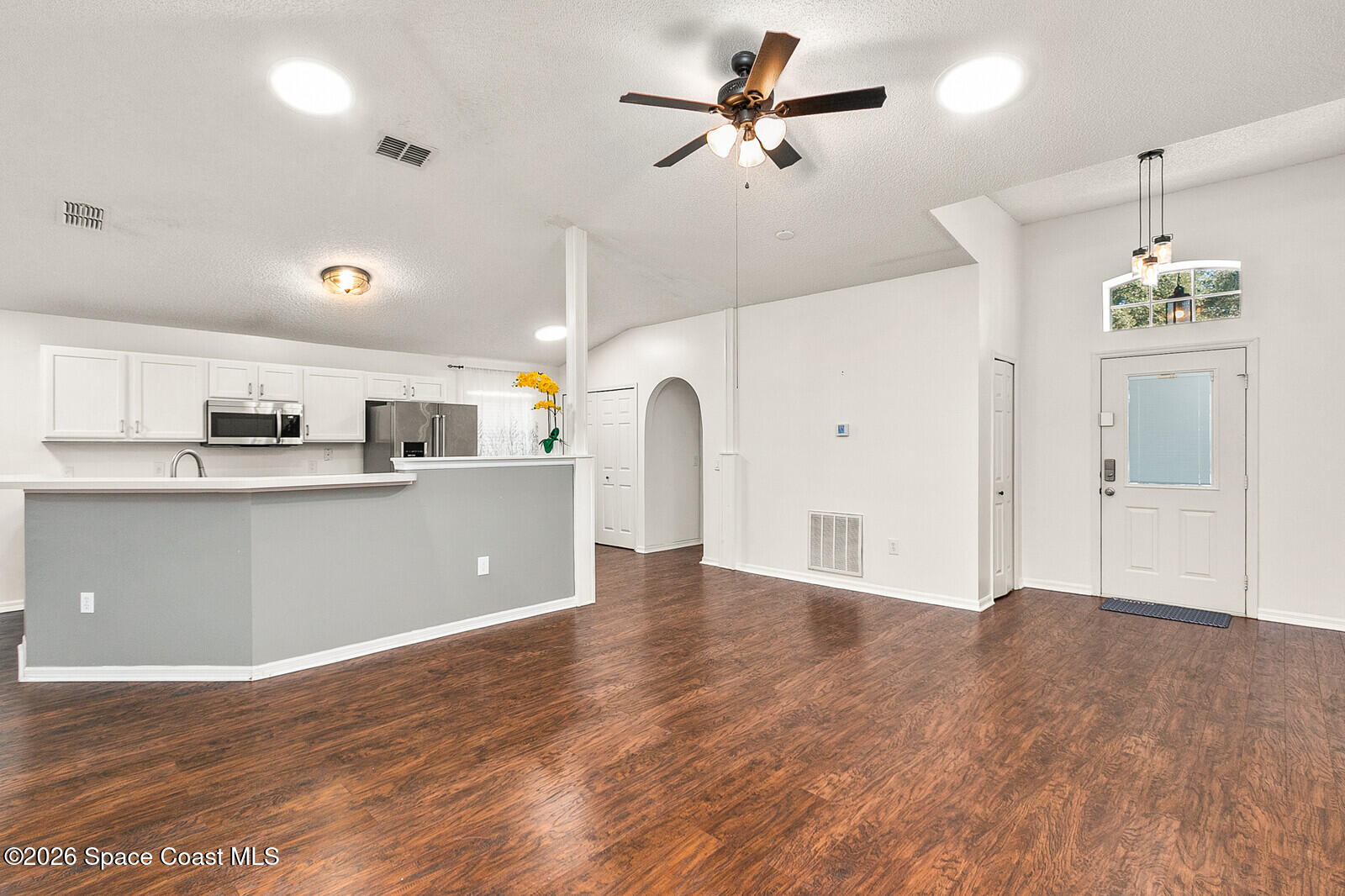 2152 Spring Creek Circle Palm Bay, FL 32905 - Photo 7 of 24 a view of a kitchen with kitchen island stainless steel appliances refrigerator and microwave