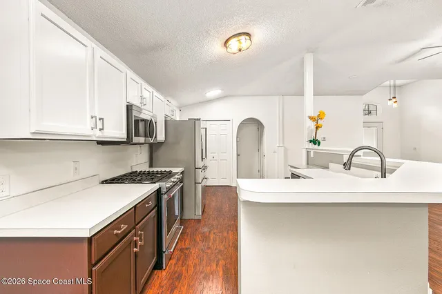 a kitchen with stainless steel appliances granite countertop a sink stove and cabinets