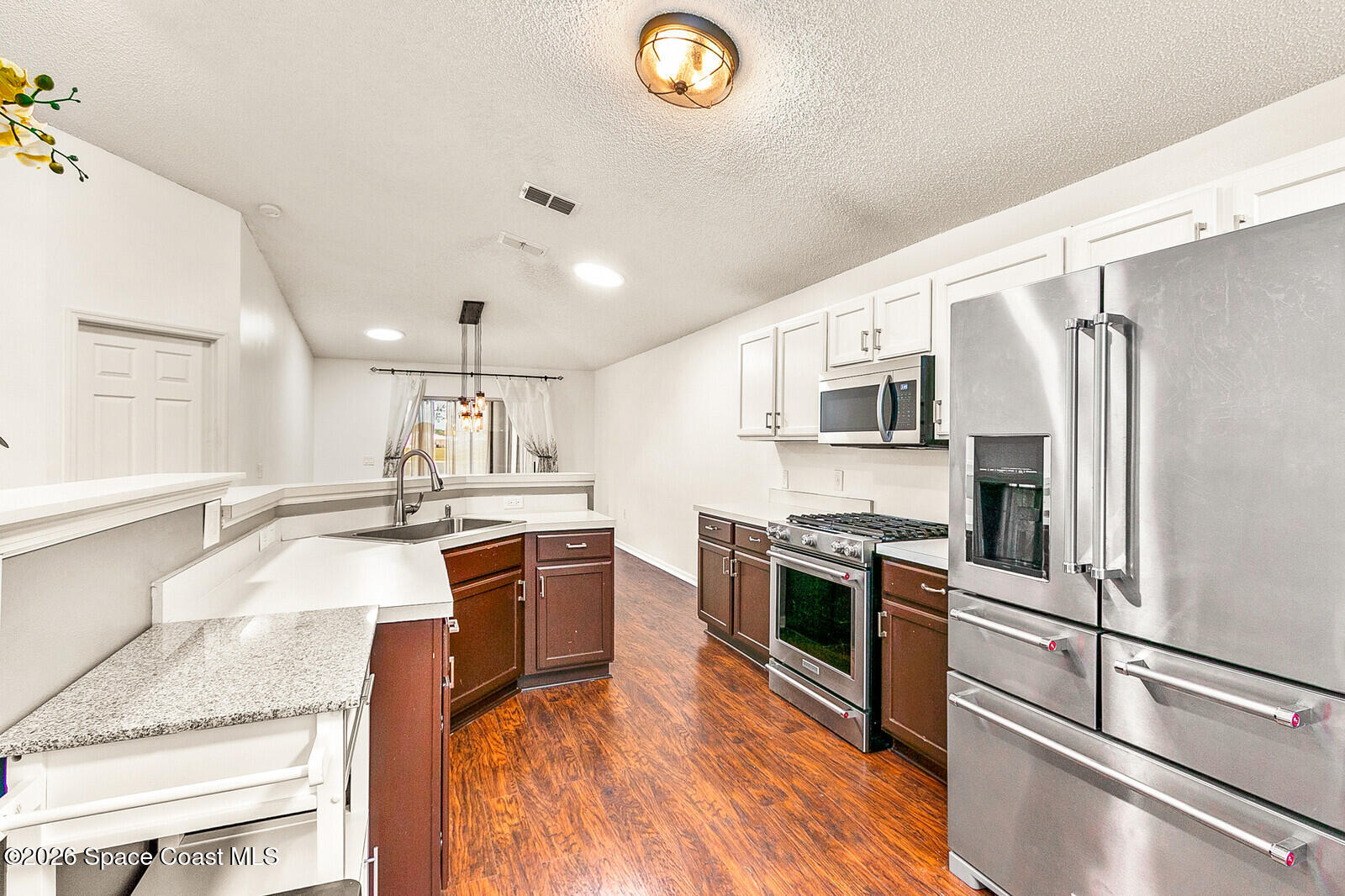 2152 Spring Creek Circle Palm Bay, FL 32905 - Photo 9 of 24 a large kitchen with stainless steel appliances granite countertop a stove refrigerator and a sink