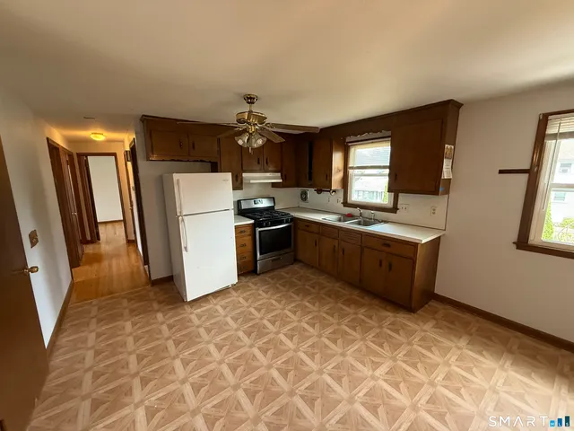 a kitchen with stainless steel appliances a stove a sink a refrigerator a window