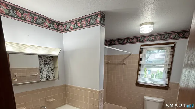 a view of a hallway with closet and a window