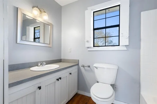 a bathroom with a toilet sink vanity and mirror