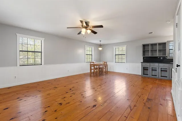 a view of a livingroom with furniture a ceiling fan and wooden floor