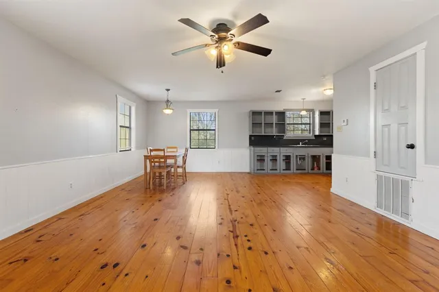 a view of a kitchen with wooden floor and a kitchen space with a sink