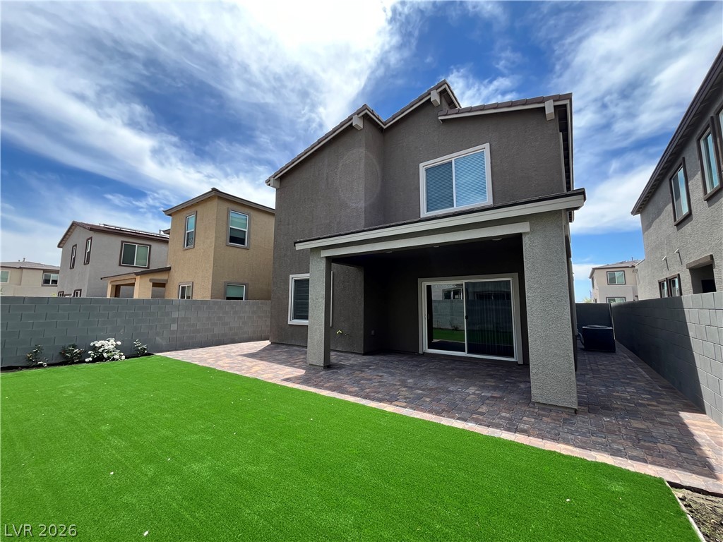 8336 Rowan Rdg Avenue Las Vegas, NV 89147 - Photo 14 of 15 This outdoor space offers a paved patio area, green yard, and privacy walls.