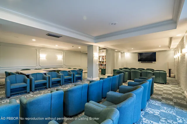 a living room with furniture a flat screen tv and kitchen view