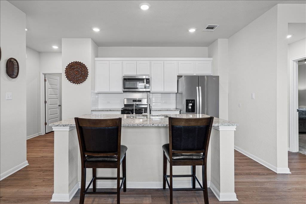 158 Gullivers Drive Elgin, TX 78621 - Photo 6 of 36 Look at the size of this center island! It features granite countertops with plenty of room for barstools.