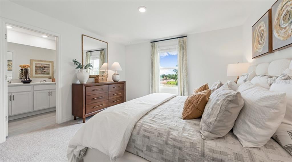 13228 Stable Place Parrish, FL 34219 - Photo 13 of 28 a bedroom with a bed and a chandelier