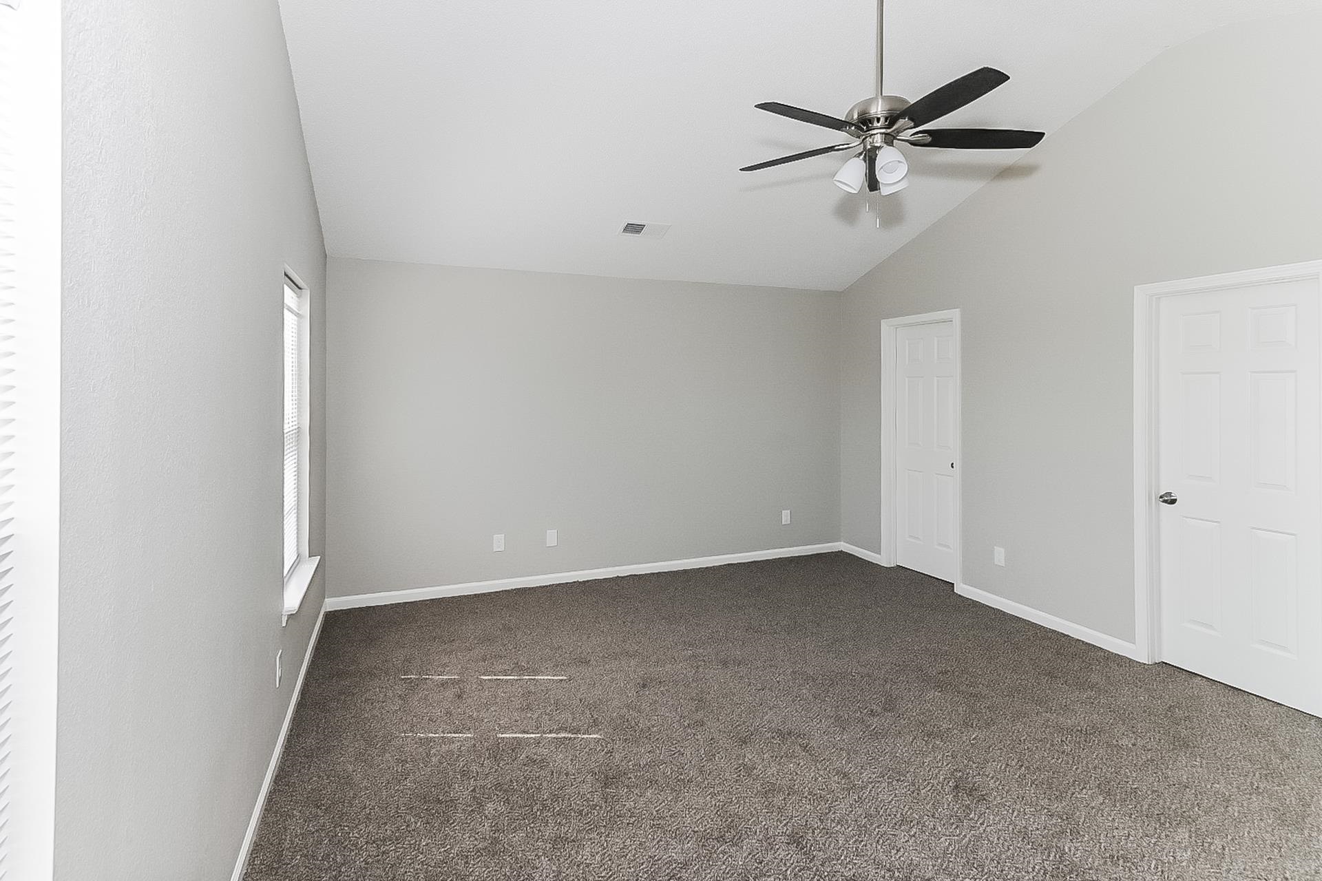4891 Top Notch Loop Memphis, TN 38125 - Photo 7 of 17 an empty room with a ceiling fan and a window
