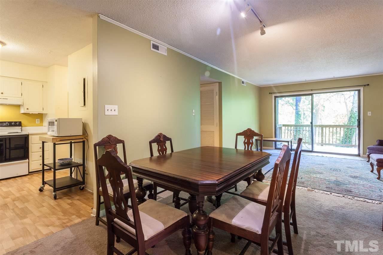 627 Pine Ridge Place, Unit NONE Raleigh, NC 27609 - Photo 7 of 21 a view of a dining room with furniture and a floor to ceiling window