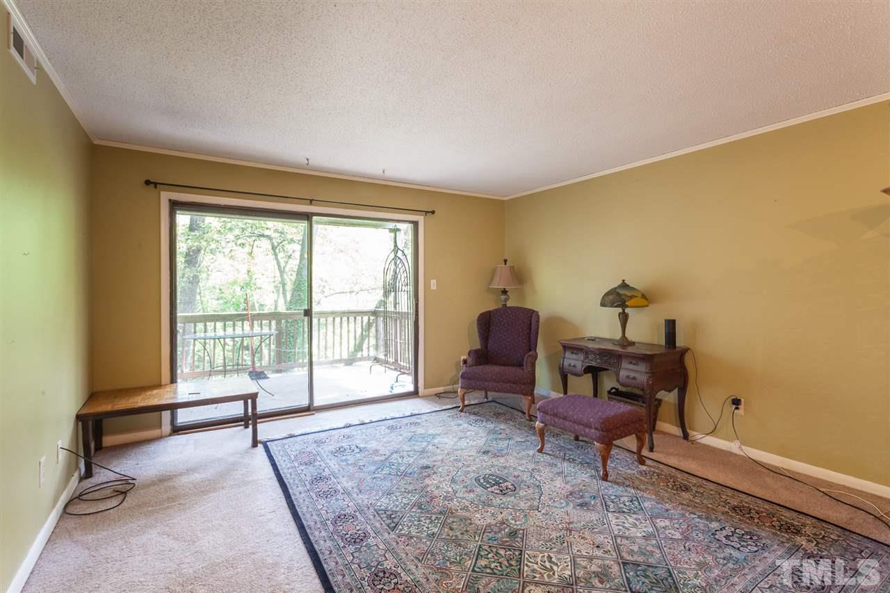627 Pine Ridge Place, Unit NONE Raleigh, NC 27609 - Photo 8 of 21 a living room with furniture and a floor to ceiling window