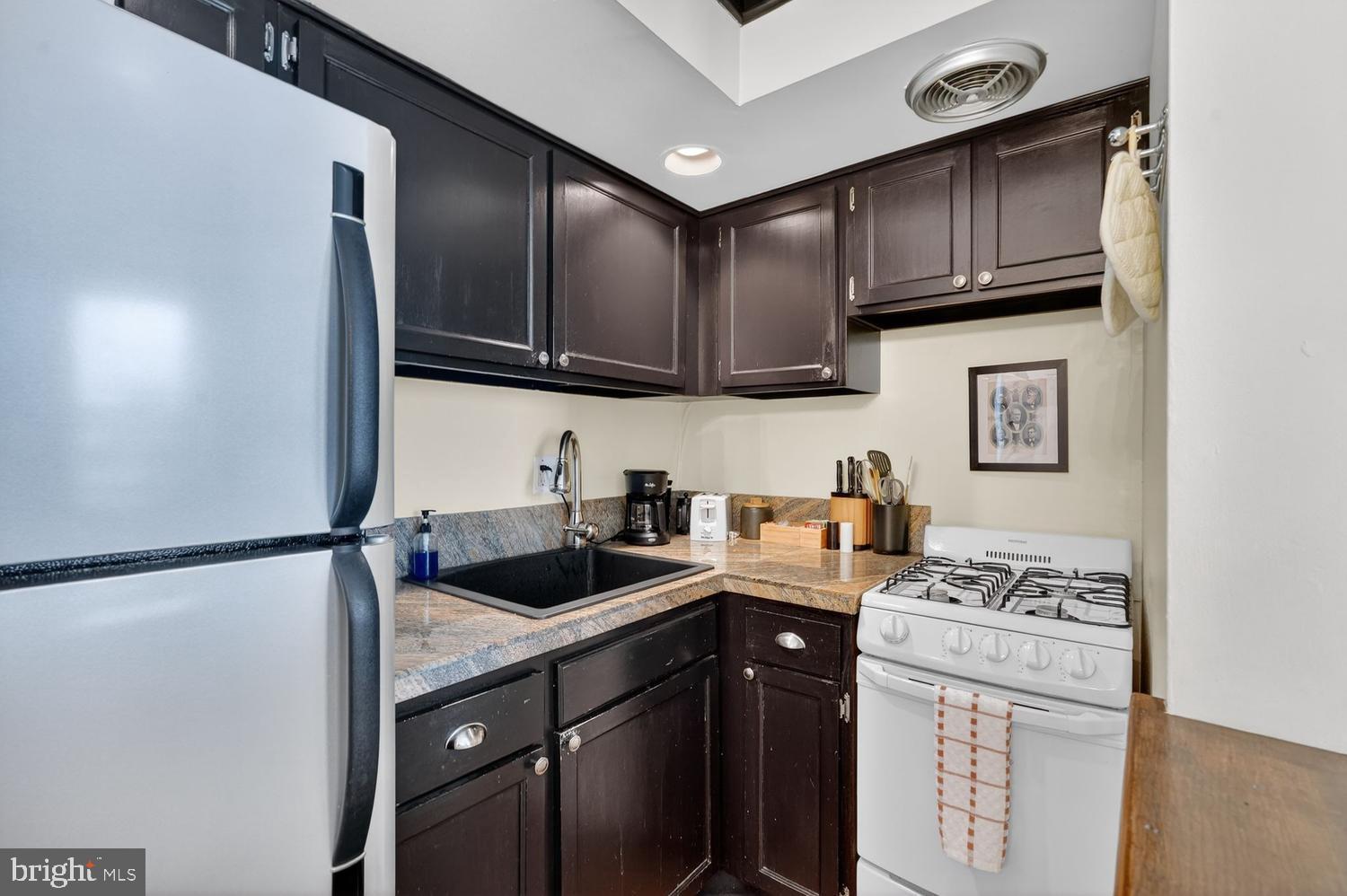 11 2nd Street Northeast, Unit 208 Washington, DC 20002 - Photo 7 of 12 a kitchen with stainless steel appliances granite countertop a sink stove and refrigerator